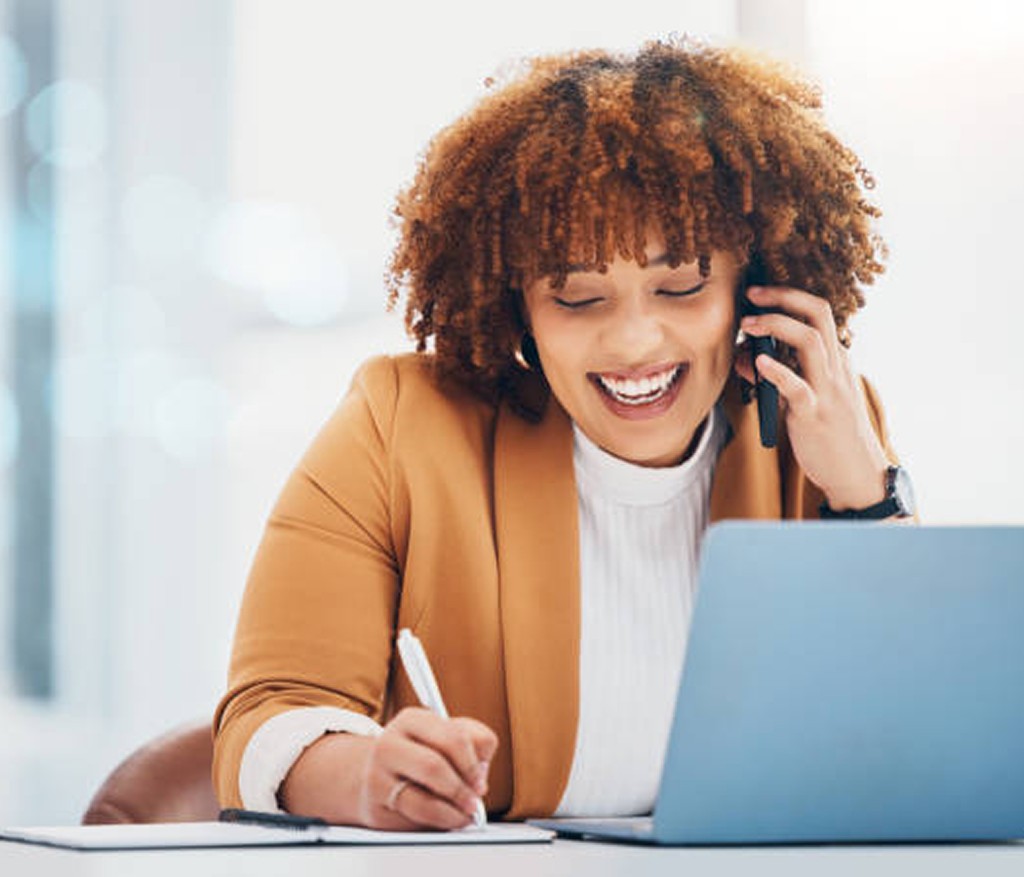 Professional multitasking on phone and notes at a laptop